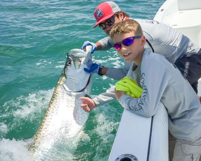 Kids enjoying a full day fishing charter in Tampa Bay with family, learning and having fun on the boat